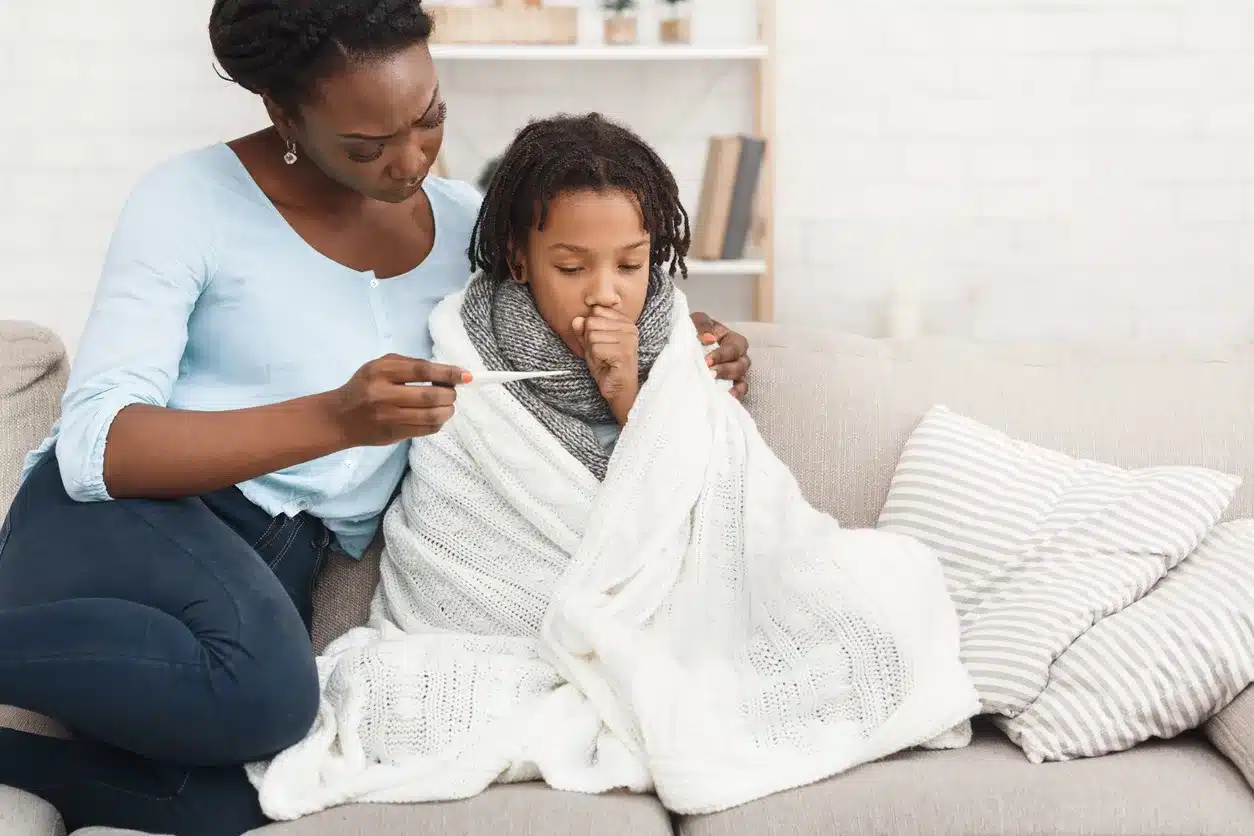 Mother measuring temperature of her sick daughter with thermometer Mother checks the temperature of her sick child.