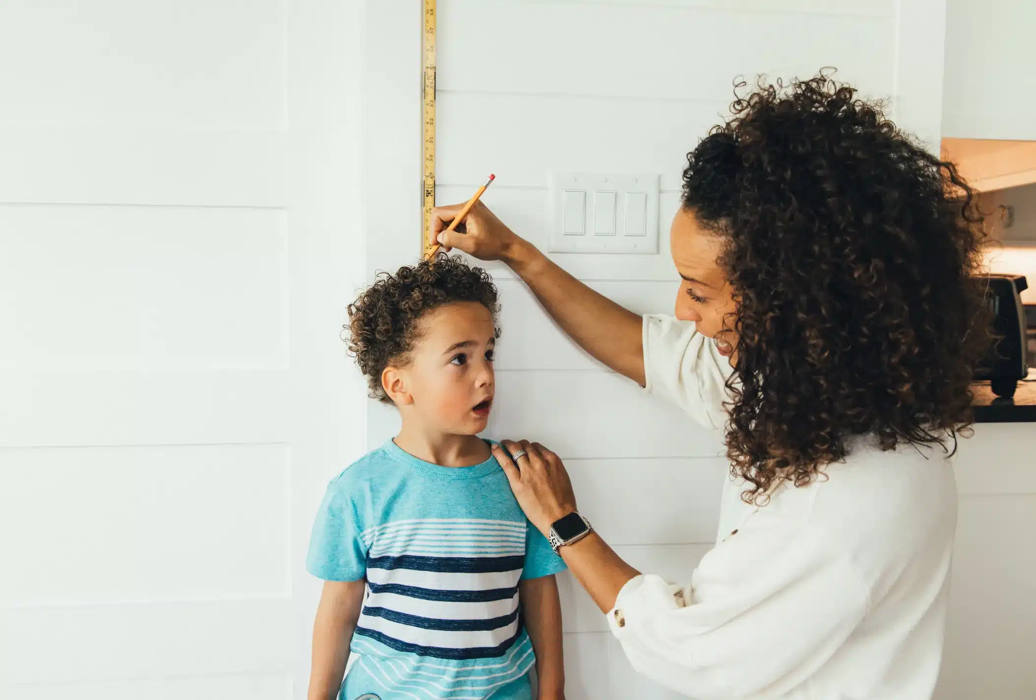Mother Measuring Height of Son
