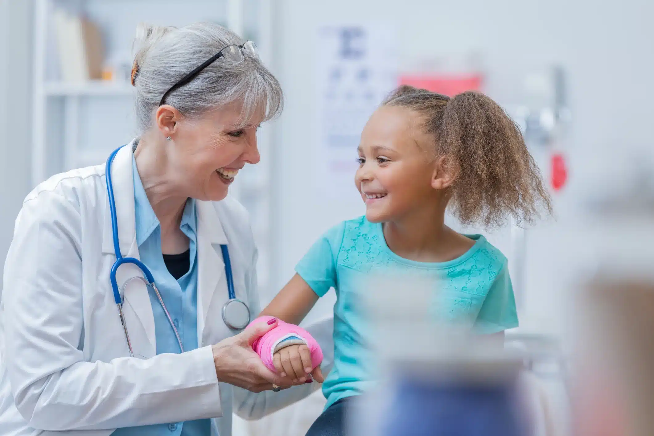 Adorable girl with broken arm talks with pediatrician